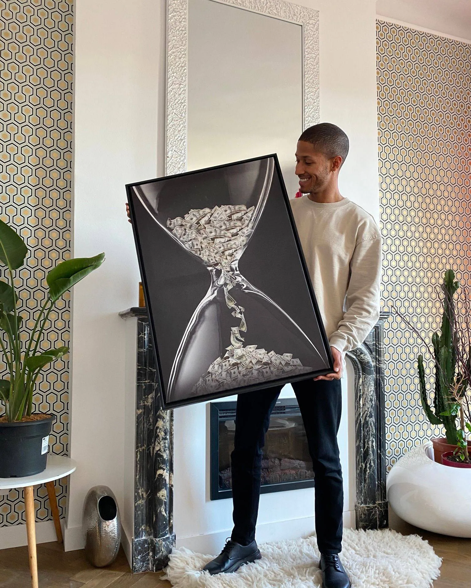 The Money Time canvas, an hourglass of falling dollar bills, held up in a living room